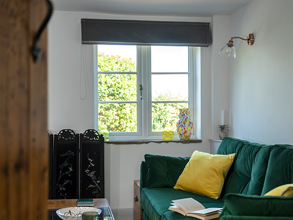 A home interior featuring a window and dark green sofa