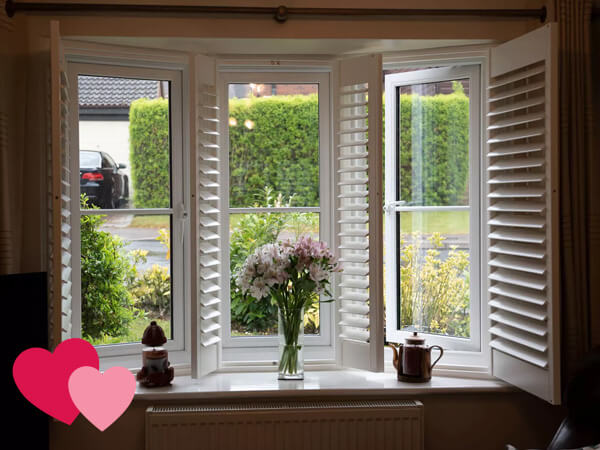 A white UPVC window with shutters