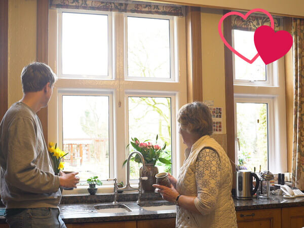 Mrs Geall and a family member observing their new windows